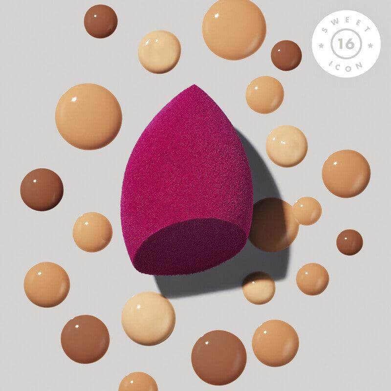 e.l.f Total Face Sponge Duo in vibrant pink surrounded by various makeup foundation drops on a light background.