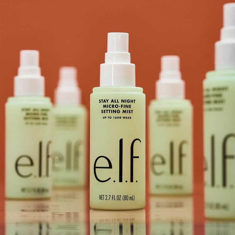 e.l.f Stay All Night Micro-Fine Setting Mist in front of other bottles, lightweight spray for 16 hours of makeup wear.