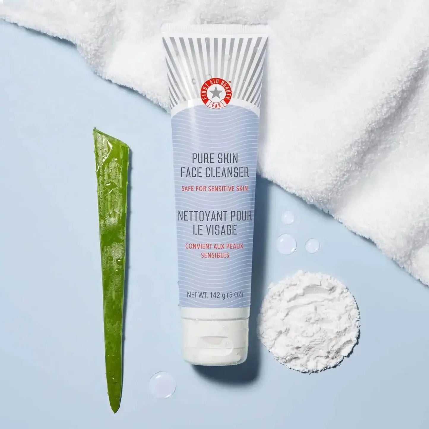 First Aid Beauty Face Cleanser 142g tube with aloe and ingredients on a soft towel background, ideal for sensitive skin.