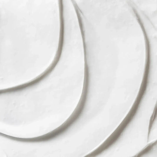 Close-up of First Aid Beauty Ultra Repair Cream texture, showcasing its rich, whipped consistency.