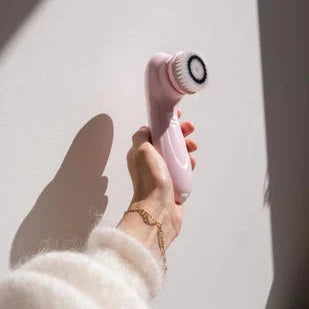 LUX SKIN® Spin Cleansing Brush in hand against a wall, perfect for deep cleansing and smooth skin at home.