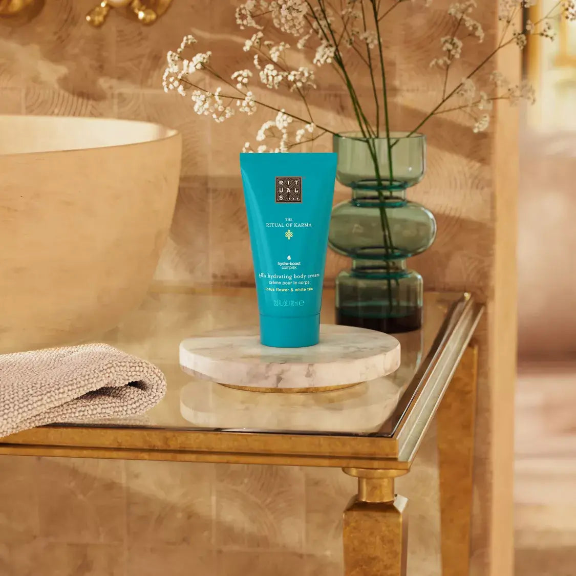 Rituals body cream on a marble stand with decorative elements in a bathroom setting
