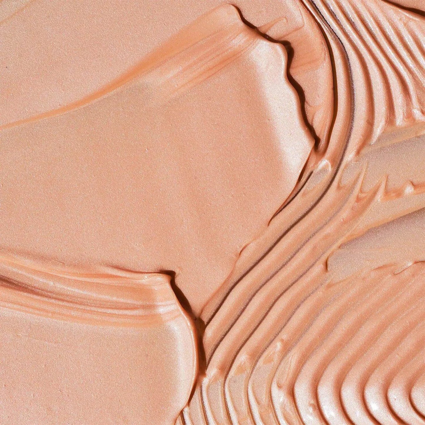 Close-up of First Aid Beauty Eye Duty Niacinamide Brightening Cream texture, showing creamy, peachy consistency.