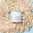 First Aid Beauty Ultra Repair Hydra-Firm Night Cream surrounded by rolled oats on a light blue background.
