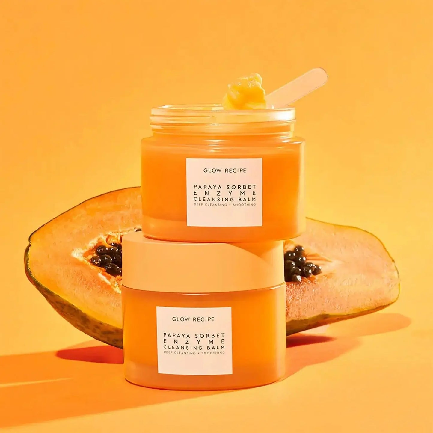 Glow Recipe Papaya Sorbet Enzyme Cleansing Balm jars with fresh papaya in the background, highlighting a bright cleansing experience.