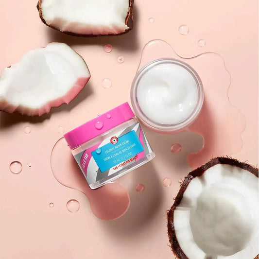 First Aid Beauty Hello Fab Coconut Water Cream 1.7 fl. oz next to fresh coconut halves, showcasing hydration and nourishment.