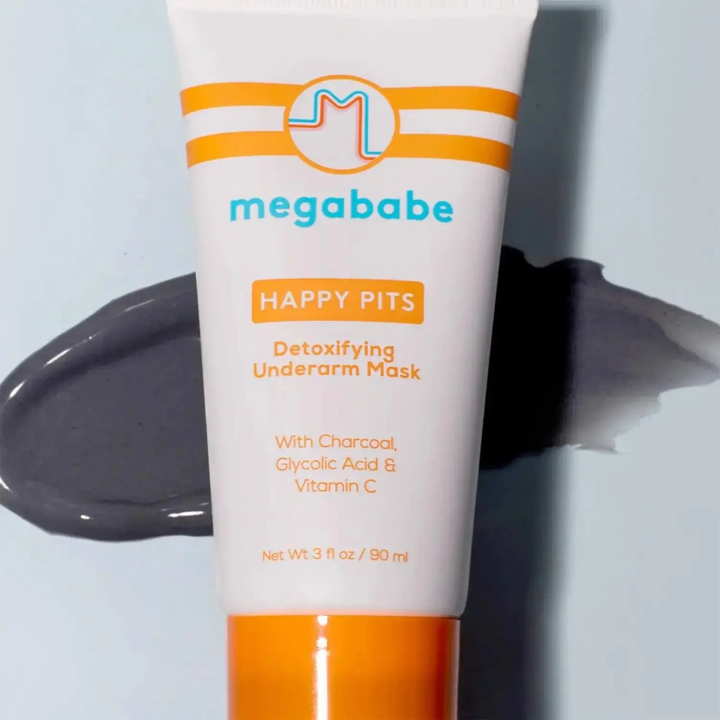 Megababe Happy Pits Detoxifying Underarm Mask 90ml tube with charcoal, glycolic acid, and vitamin C on a gray background.