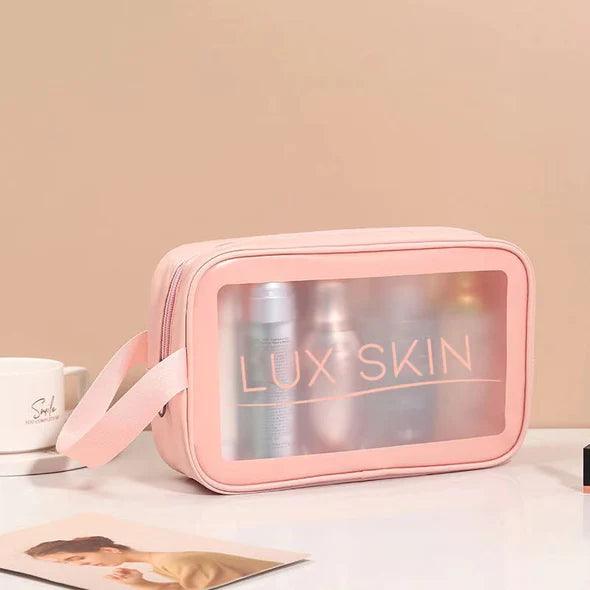LUX SKIN® Cosmetic Travel Bag in pink, showcasing beauty products inside through a clear window, ideal for travel.