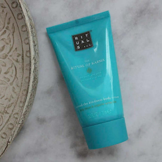 RITUALS The Ritual of Karma Body Cream tube on marble surface, enriched with lotus flower and white tea for hydration.