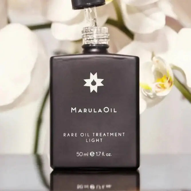 Paul Mitchell MarulaOil Rare Oil Treatment 50ml bottle against soft flower background, ideal for fine hair nourishment.