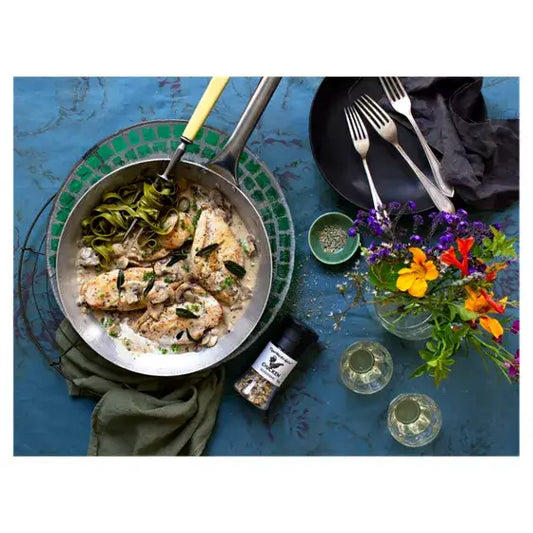 Cooked chicken meal seasoned with Cape Herb & Spice Chicken Seasoning Grinder, served with green noodles and garnished with herbs.