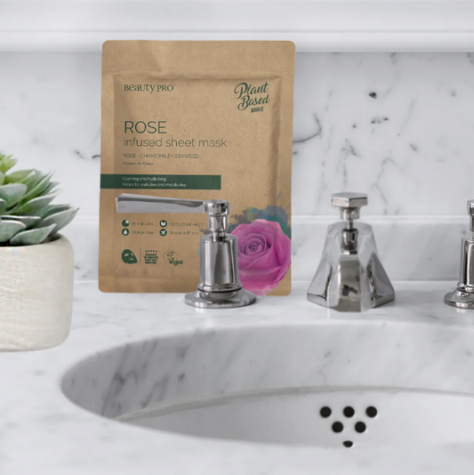 BeautyPro Rose-infused sheet mask packaging on a marble sink with decorative elements.