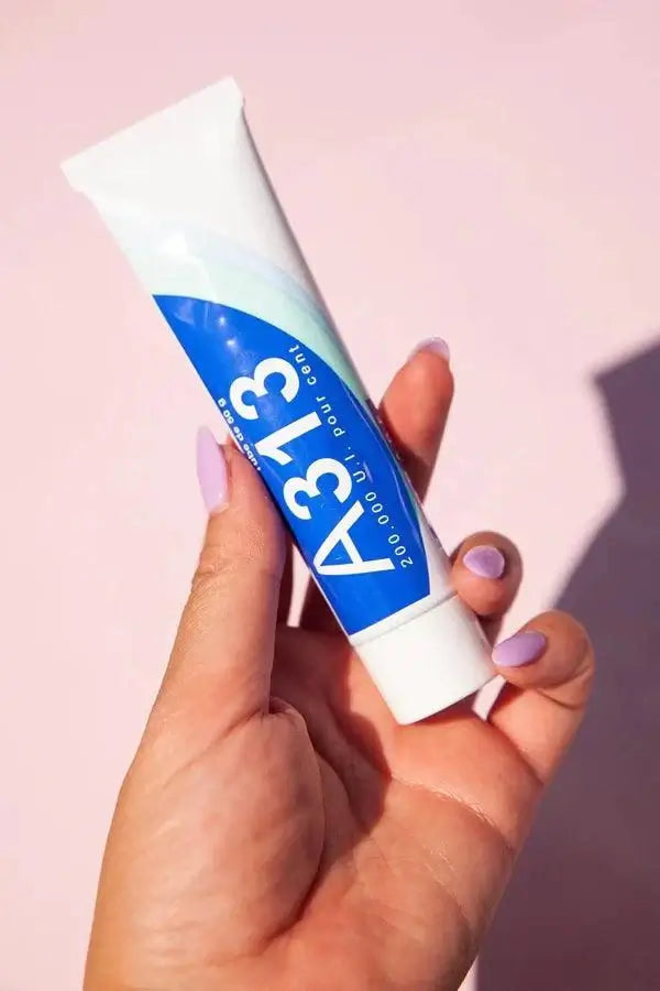 A313 Pommade 50g in hand, showcasing its sleek tube design for youthful, radiant skin.