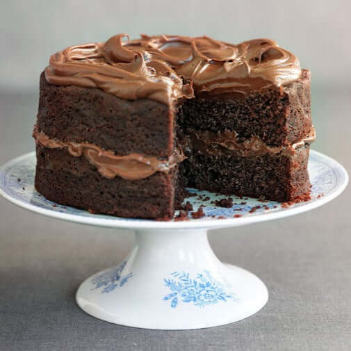 Delicious ASDA Chocolate Sponge Cake with rich frosting on a decorative cake stand.