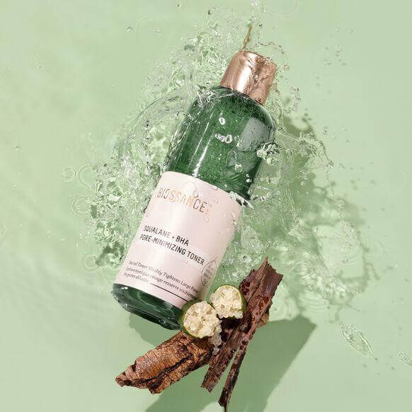 BIOSSANCE Squalane + BHA Pore Minimizing Toner 120ml with willow bark extract splashing in water.
