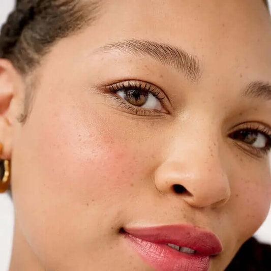 Close-up of a woman showcasing perfectly shaped brows and natural makeup, highlighting Benefit 24-HR Brow Setter.
