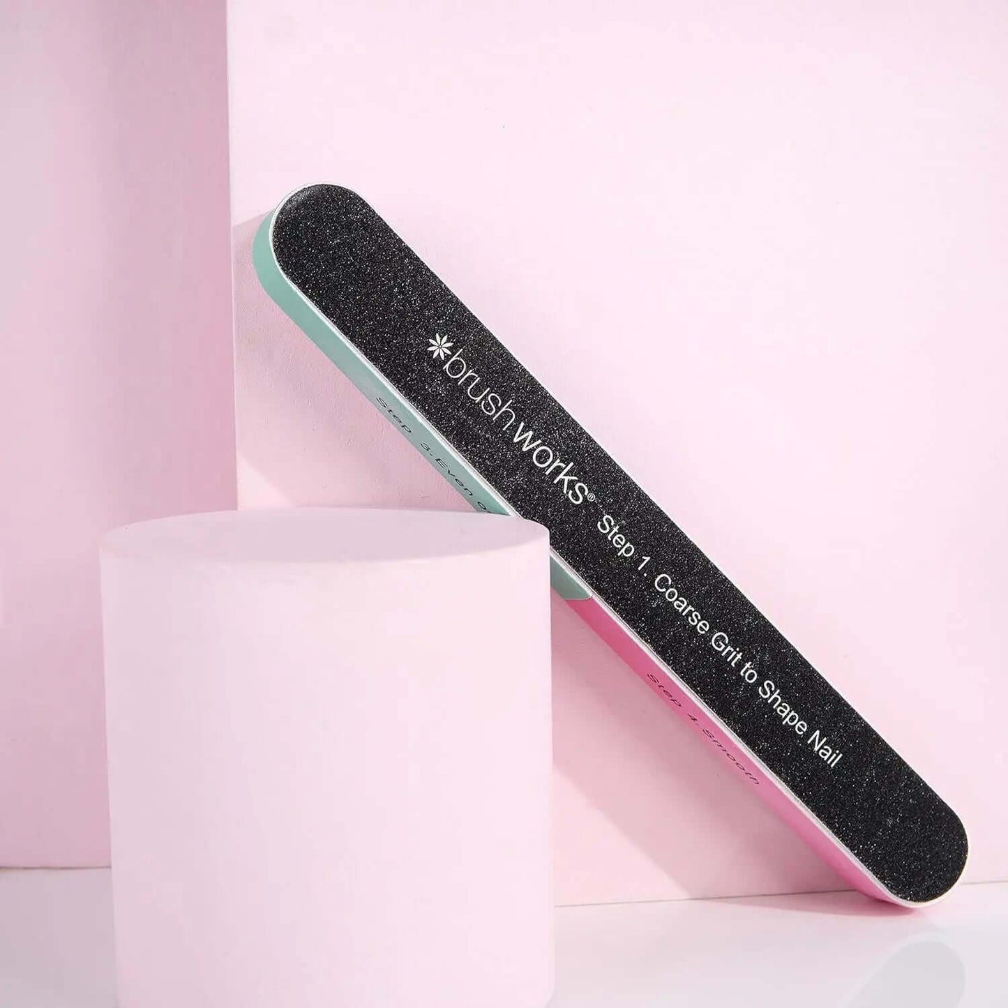 Brushworks 6 Way Shape and Shine Nail Buffer on a pink background, designed for smoothing and enhancing nail shine.