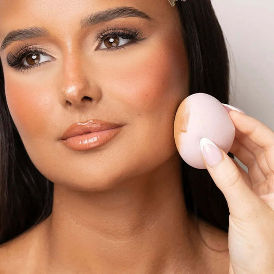 Model showcasing Brushworks Blending Drops makeup sponge for seamless blending of cream products.
