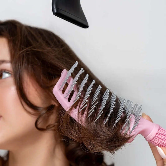 Brushworks Blow Dry Paddle Brush in use, providing a salon-quality blow-dry on curly hair with a hairdryer.