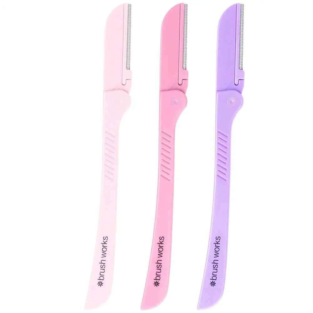 Set of Brushworks Eyebrow Razors in pink and purple for painless eyebrow shaping and exfoliation.