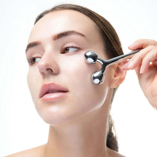 Woman using Brushworks Face Sculpting Zinc Roller for a cooling facial massage and skin toning.