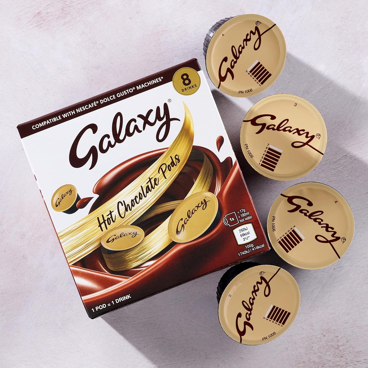 Galaxy hot chocolate pods packaging with multiple pods on a light gray background
