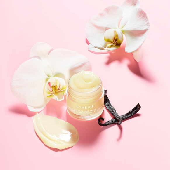 Laneige cream jar with vanilla bean and orchids on a pink background