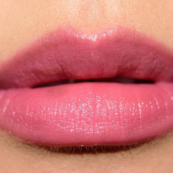 Close-up of lips wearing MAC Lustreglass Lipstick in Syrup, a blue-toned medium-dark pink with a glossy finish.