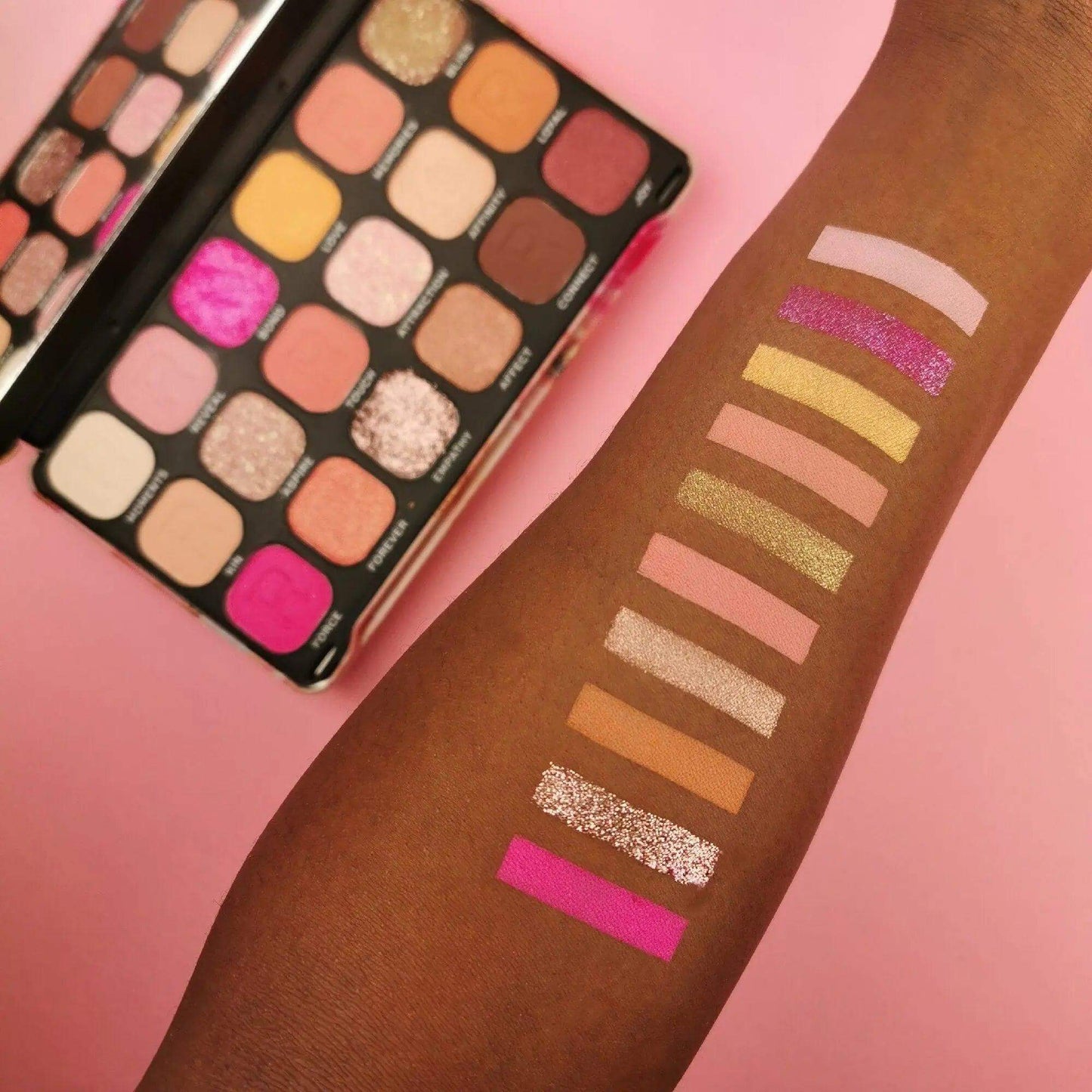 Swatches of Revolution Makeup Forever Flawless Affinity Palette on skin, showcasing vibrant matte and shimmer eyeshadows.