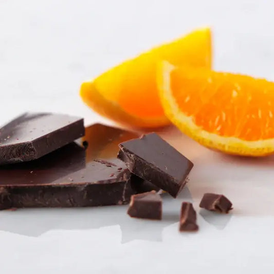 Dark chocolate pieces with fresh orange slices, a perfect pairing for a delightful snack experience.