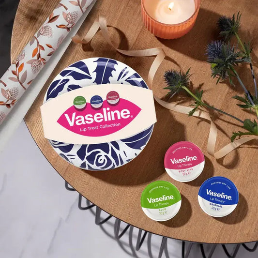 Vaseline lip balm collection on a wooden table with decorative elements.