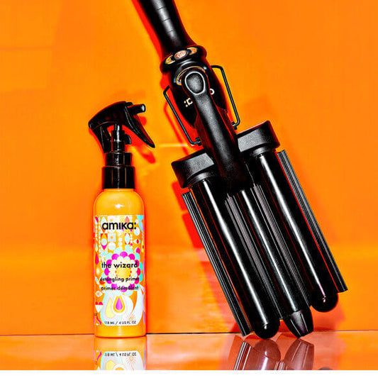 Amika Deep Waver High Tide with The Wizard styling spray against an orange backdrop, perfect for effortless waves.