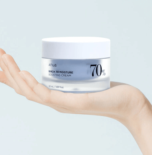 Anua Birch 70% Moisture Boosting Cream in a hand, showcasing its hydrating properties for radiant skin.