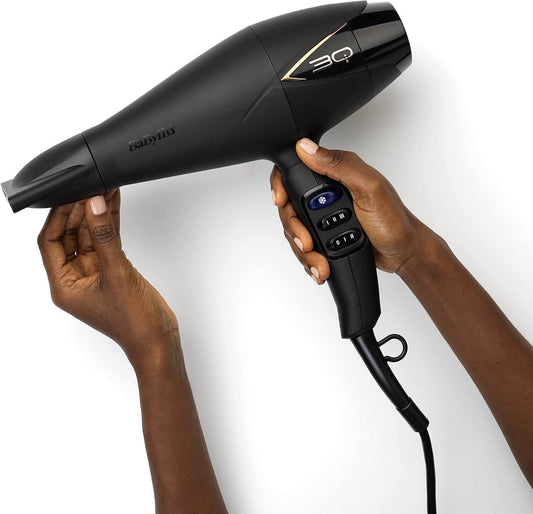 BaByliss 3Q Hair Dryer held in hands, showcasing its sleek design and advanced control features for professional styling.