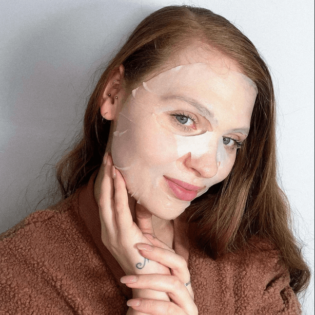 Woman applying BeautyPro SQUALANE Nourishing Facial Sheet Mask for radiant skin and rejuvenation.