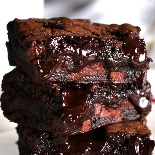 Stack of gooey chocolate fudge brownies with a rich, glossy topping, perfect for chocolate lovers.