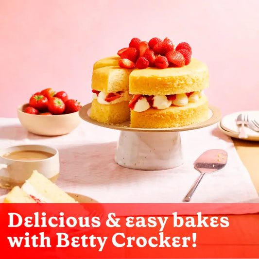 Delicious vanilla cake topped with strawberries and cream, showcasing Betty Crocker Bake Smart products for easy homemade baking.