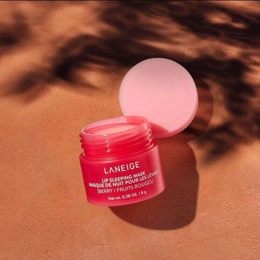 LANEIGE Lip Sleeping Mask Berry 8g jar on a textured surface; nourishing formula for soft, smooth lips overnight.