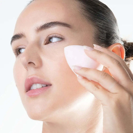 Woman applying makeup with Brushworks Complexion Sponge for a flawless finish and natural look.
