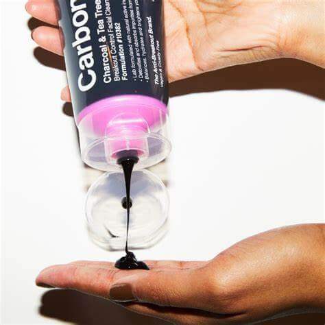 Carbon Theory Charcoal & Tea Tree Oil Facial Cleansing Wash being poured into a hand.