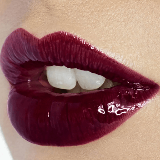 Close-up of glossy lips showcasing a deep burgundy shade, perfect for a bold makeup look.