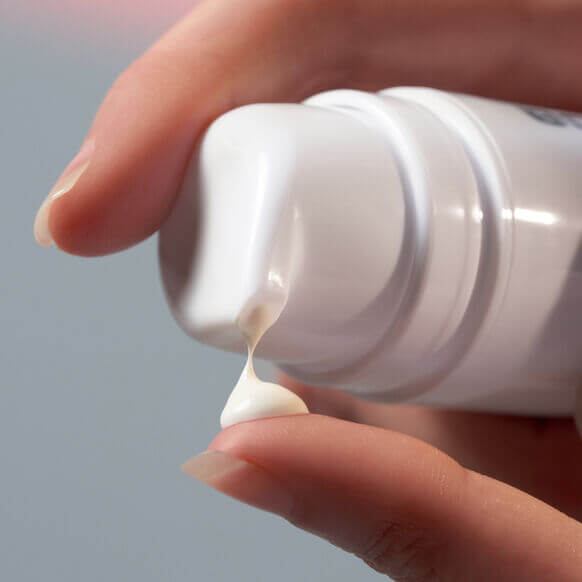 Dermalogica Dynamic Skin Recovery SPF 50 being dispensed onto a finger, showcasing its creamy texture.