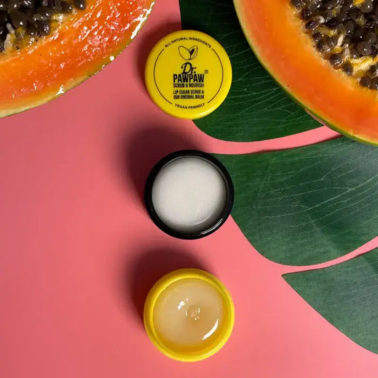 Dr. Pawpaw skincare products on a pink background with a halved papaya and leaves.