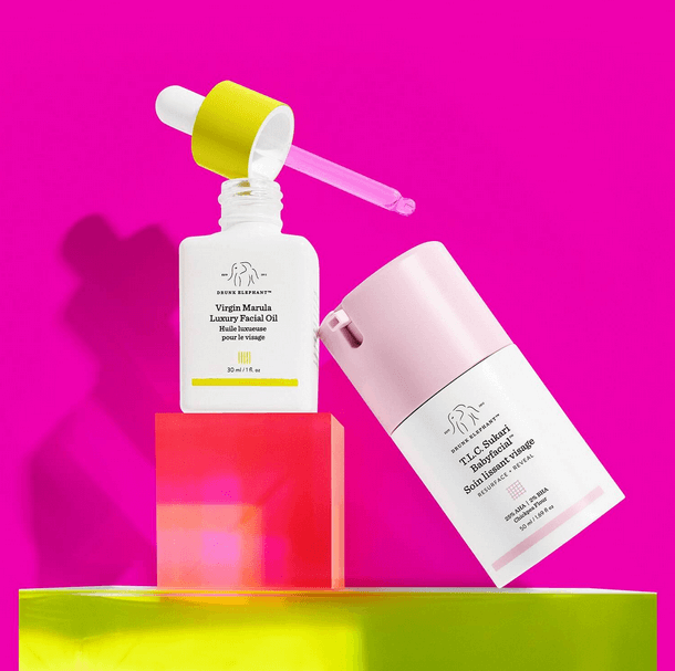 Drunk Elephant T.L.C. Sukari Babyfacial and Virgin Marula Luxury Facial Oil on bright pink background.