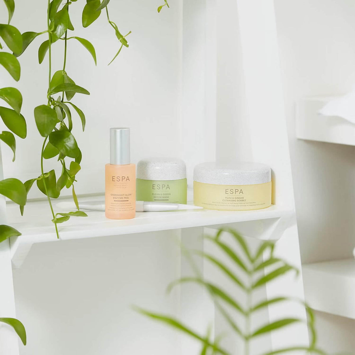 ESPA skincare products on a white shelf with greenery