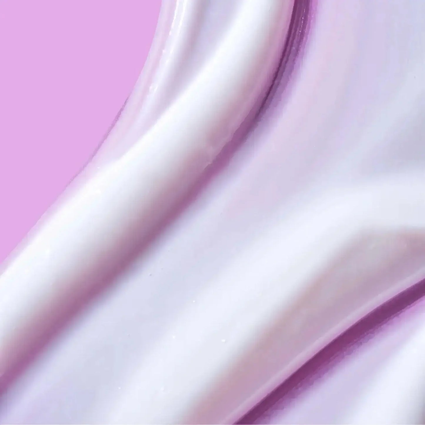 Close-up of creamy body lotion texture on a pink background, indicating smooth and hydrating qualities.