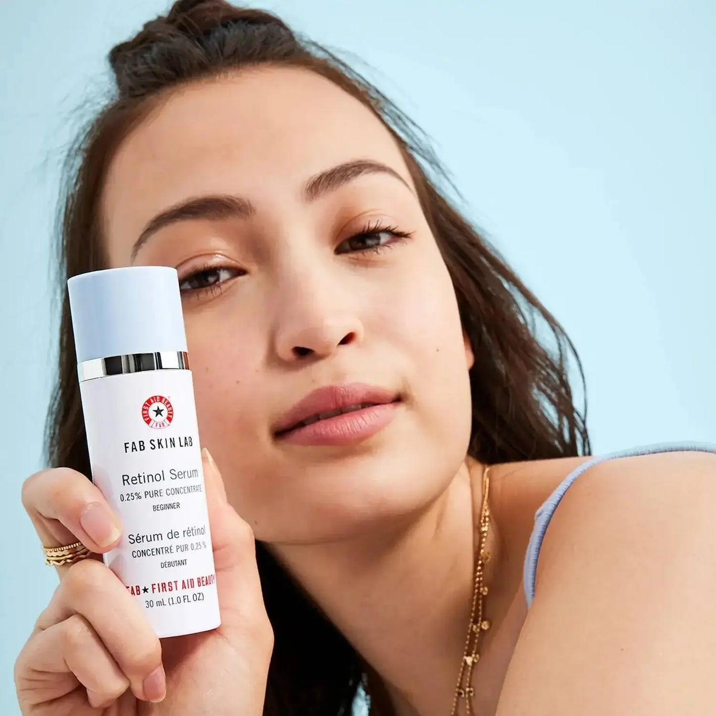 First Aid Beauty Skin Lab Retinol Serum 0.25% Pure Concentrate 30ml held by a model, ideal for sensitive skin.