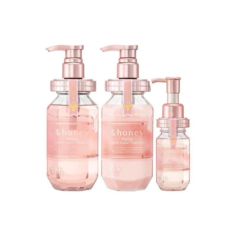 Three skincare bottles with pink labels and rose gold pumps on a white background