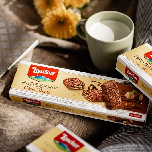 Loacker Patisserie Crème Noisette wafer box with hazelnut chocolate wafers and a cup of milk.