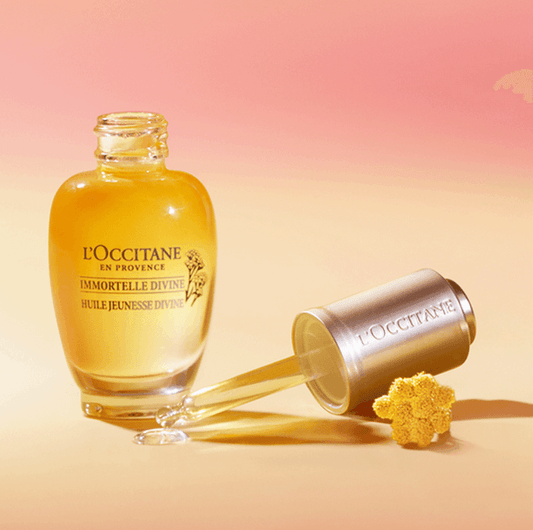 L'Occitane Immortelle Divine Youth Oil 15ml bottle with dropper and flower, ideal for skin rejuvenation.